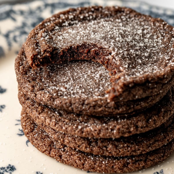 Chewy chocolate cookies stacked together with bite taken out of top cookie.