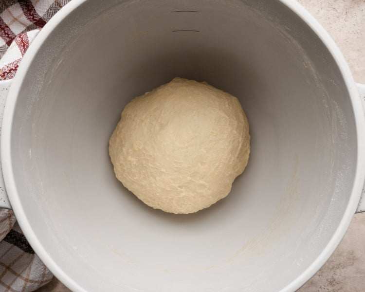 Close-up image of the finished dough formed into a smooth ball in a mixing bowl, ready for its first rise.