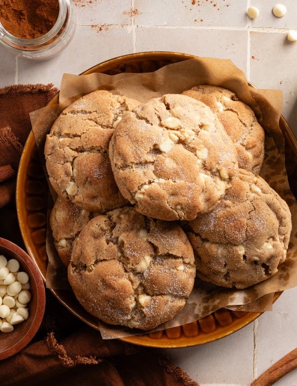 Giant snickerdoodle cookies stacked in bowl.