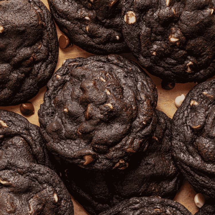 Black and white chocolate chip cookies baked and placed on parchment paper.