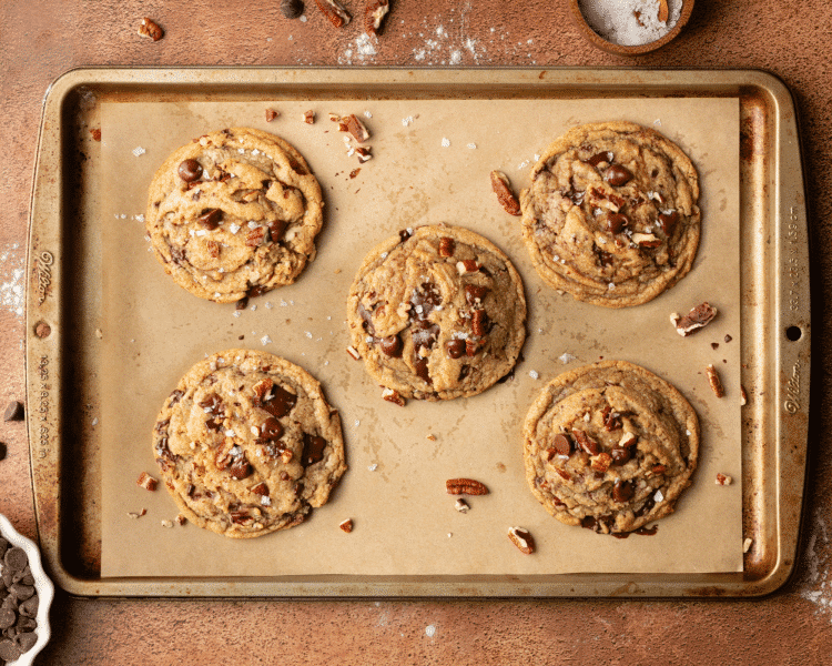 Brown butter pecan chocolate chip cookies baked on cookie sheet.