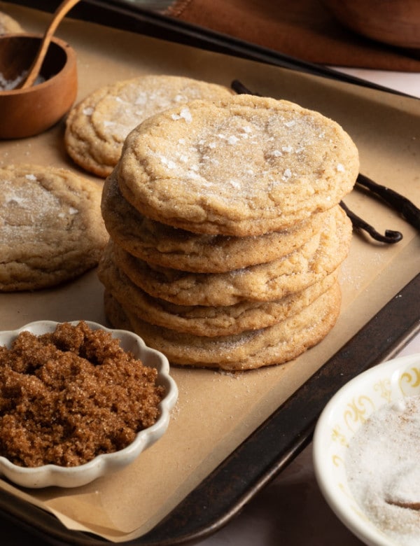 Five brown sugar cookies stacked on baking tray.