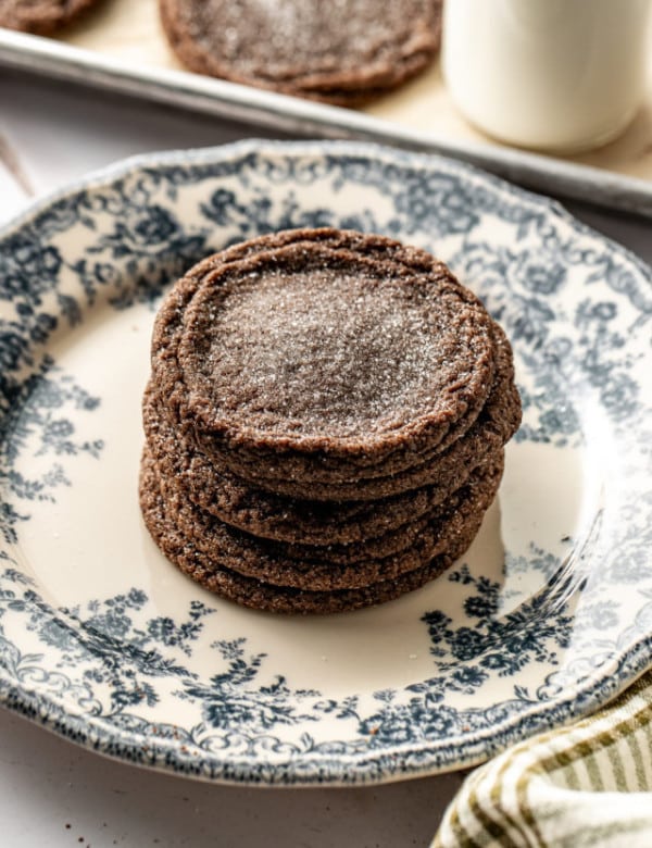 Chewy chocolate chip cookies stacked on top of each other on blue floral plate.