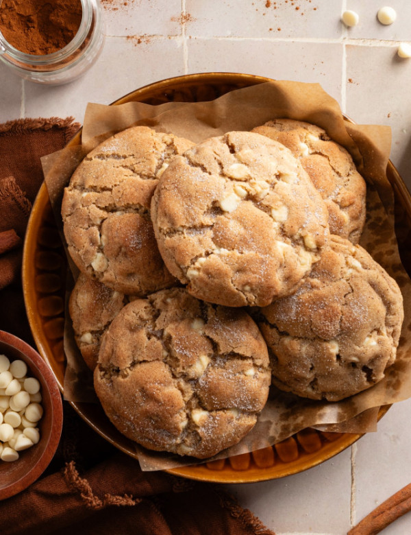 Giant snickerdoodle cookies stacked in bowl.