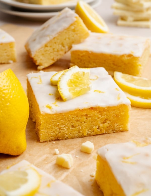 Lemon brownie square garnished with lemon wedges and lemon zest.