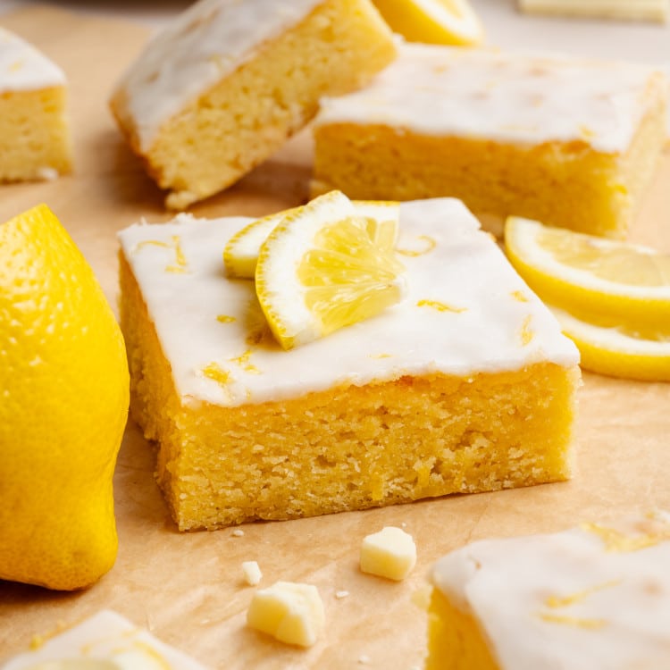 Lemon brownie square garnished with lemon wedges and lemon zest.