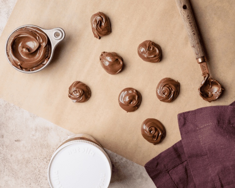 Nutella scooped out onto parchment paper to place in the freeze before adding to cookie dough.