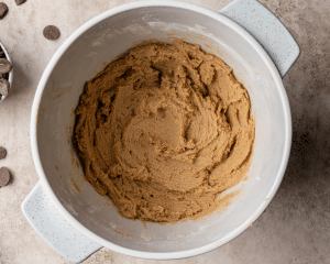 Wet and dry ingredients combined in bowl to make cookie dough.
