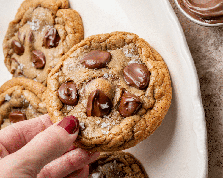 Hand holding nutella stuffed chocolate chip cookie.