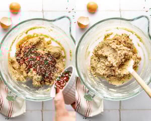 Red and green sprinkles being poured into the cookie dough in a glass bowl, then folded in with a spatula.