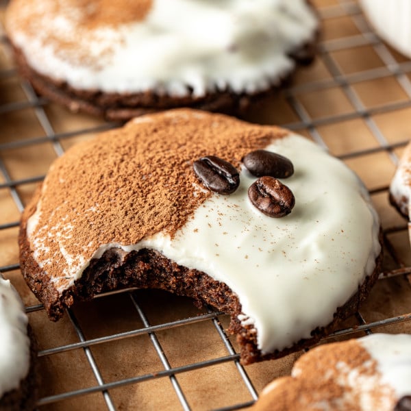 Espresso martini cookie on wire rack with bite taken out of the middle of the cookie.