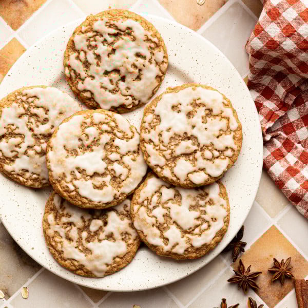 Six iced gingerbread oatmeal cookies on a plate.