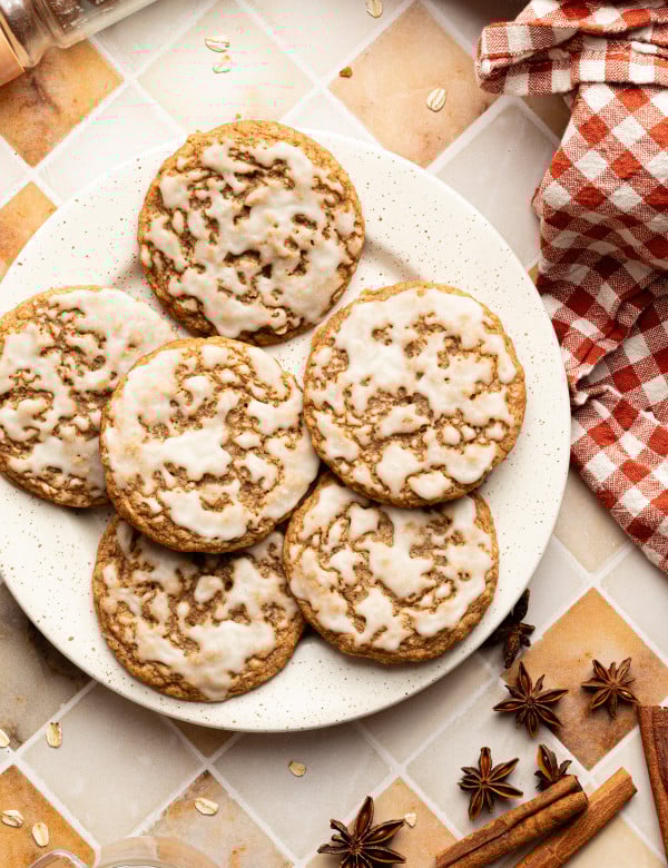 Six iced gingerbread oatmeal cookies on a plate.