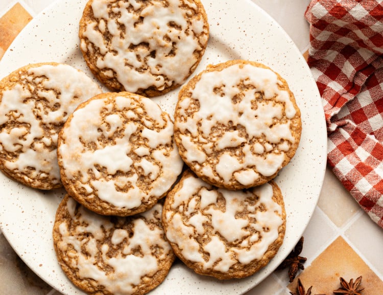 Six iced gingerbread oatmeal cookies on a plate.