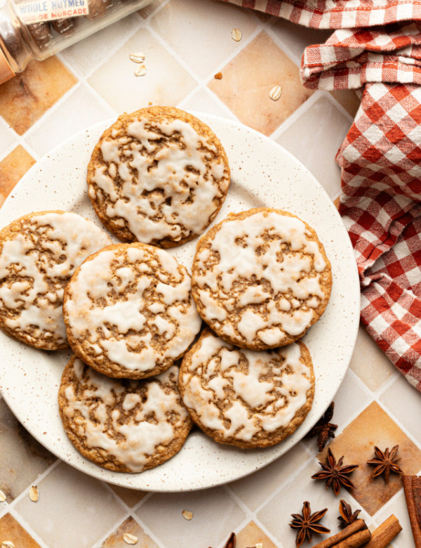 Six iced gingerbread oatmeal cookies on a plate.