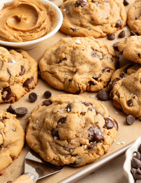 Scooping on peanut butter cookie off a baking tray.