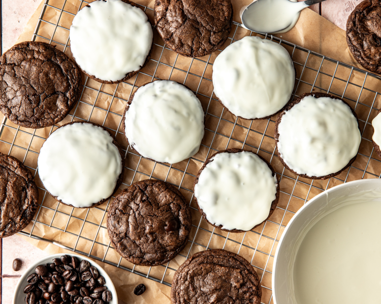 Dipping the cooled espresso martini cookies in white chocolate than placing them on a wire rack to set.