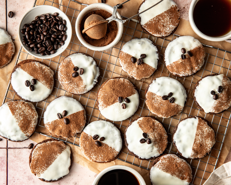Garnishing the espresso martini cookies with cocoa powder and coffee beans on wire rack.