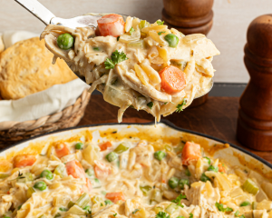 Spoon holding up portion of pot pie orzo.