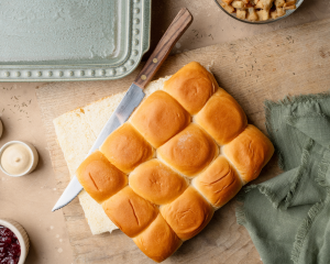 Slicing hawaiian rolls in half.