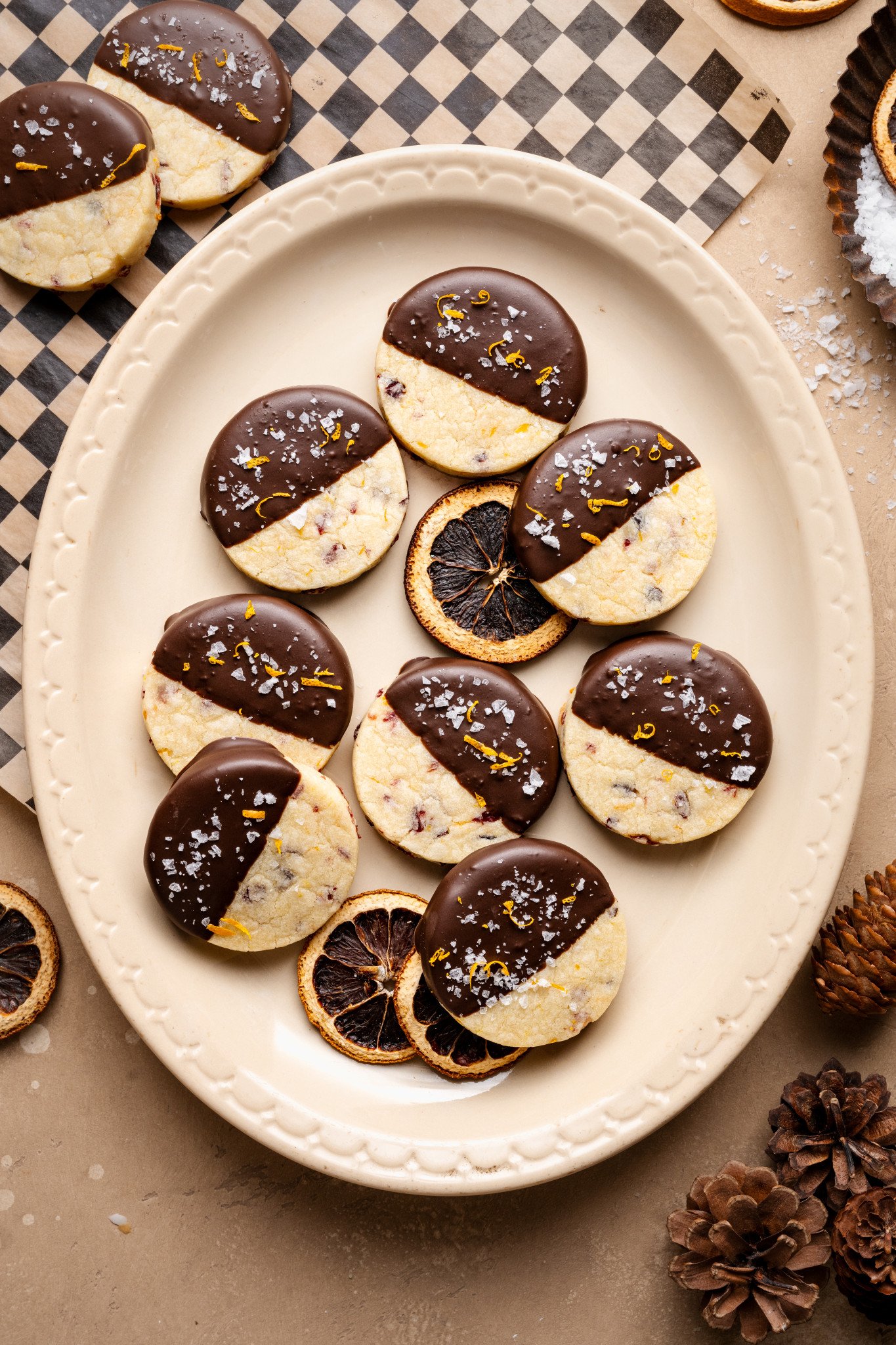 Chocolate-dipped cranberry orange shortbread cookies on platter.