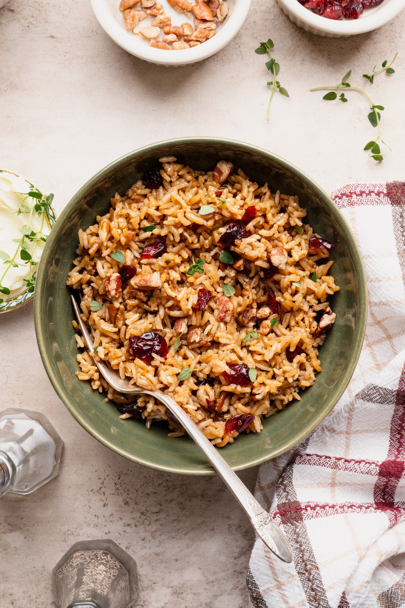 Holiday stick of butter rice recipe served in a green bowl with fork.