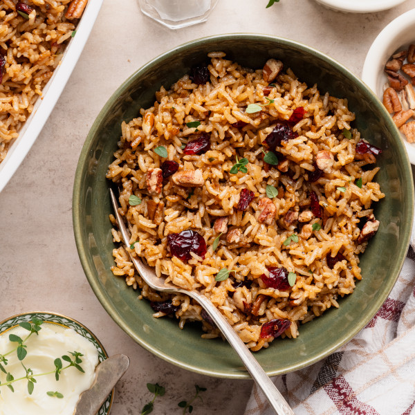 Holiday stick of butter rice in a green bowl with fork.