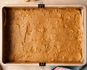 Spreading cookie bar dough into prepared 9x13 inch pan.