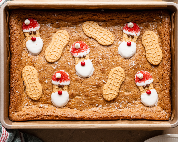 Topping baked nutter butter cookie bars with decorated and plain Nutter Butters.