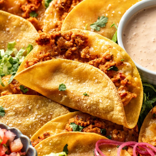 Ground chicken taco baked and set on top of tray of more baked chicken tacos.