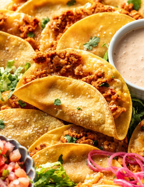 Ground chicken taco baked and set on top of tray of more baked chicken tacos.