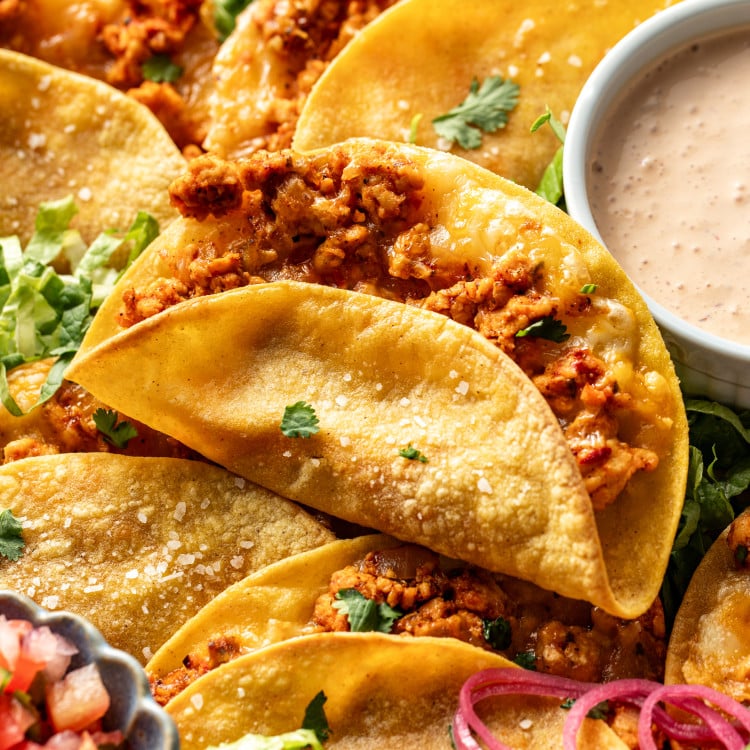 Ground chicken taco baked and set on top of tray of more baked chicken tacos.