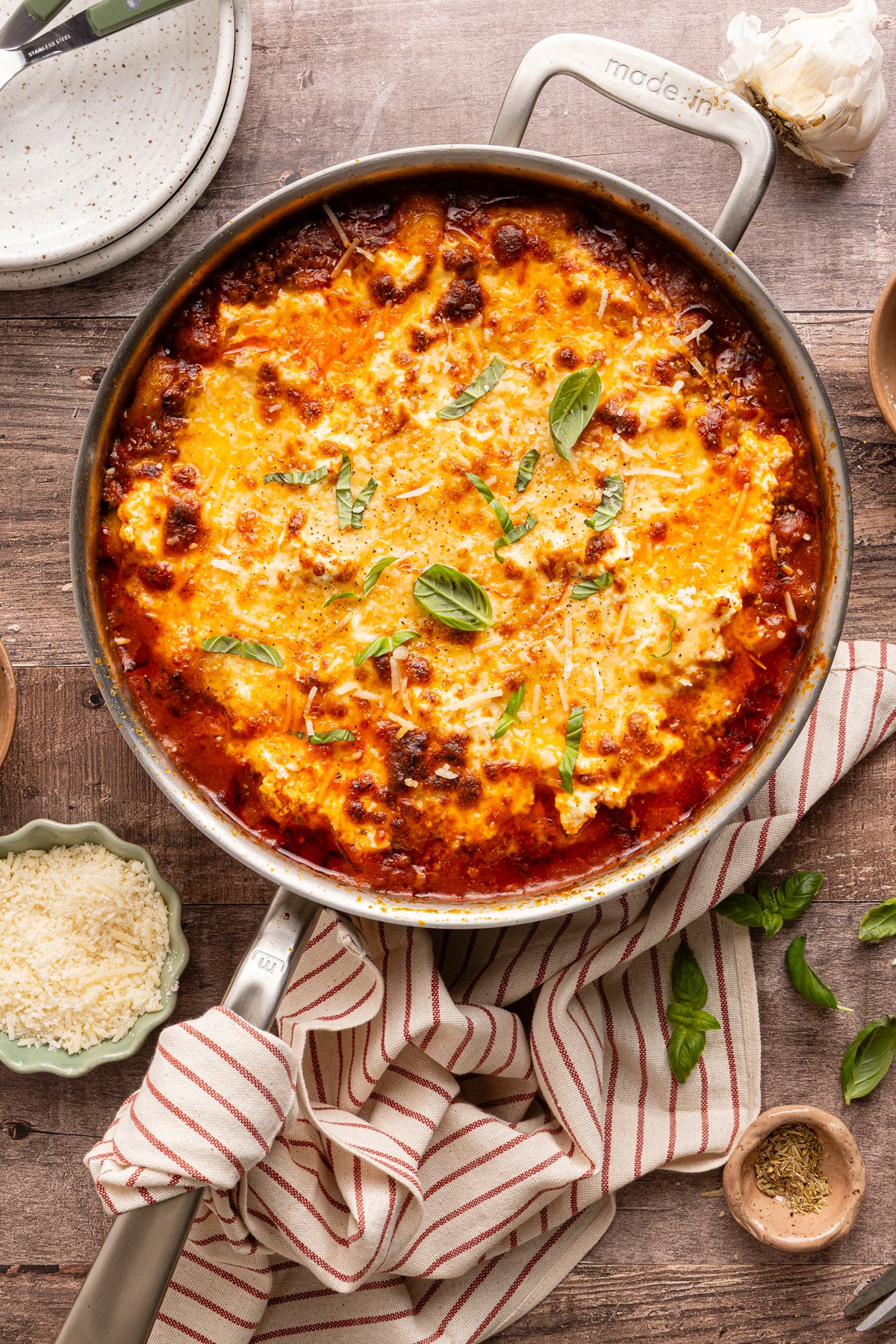 Gnocchi lasagna baked in stainless pot and garnished with fresh basil.