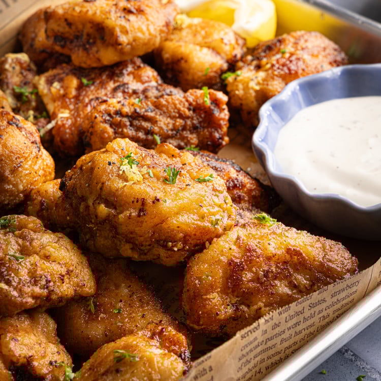 Cooked lemon pepper wings on parchment-lined baking tray.