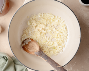 Adding the onions and garlic to the dutch oven and sauteing until fragrant.