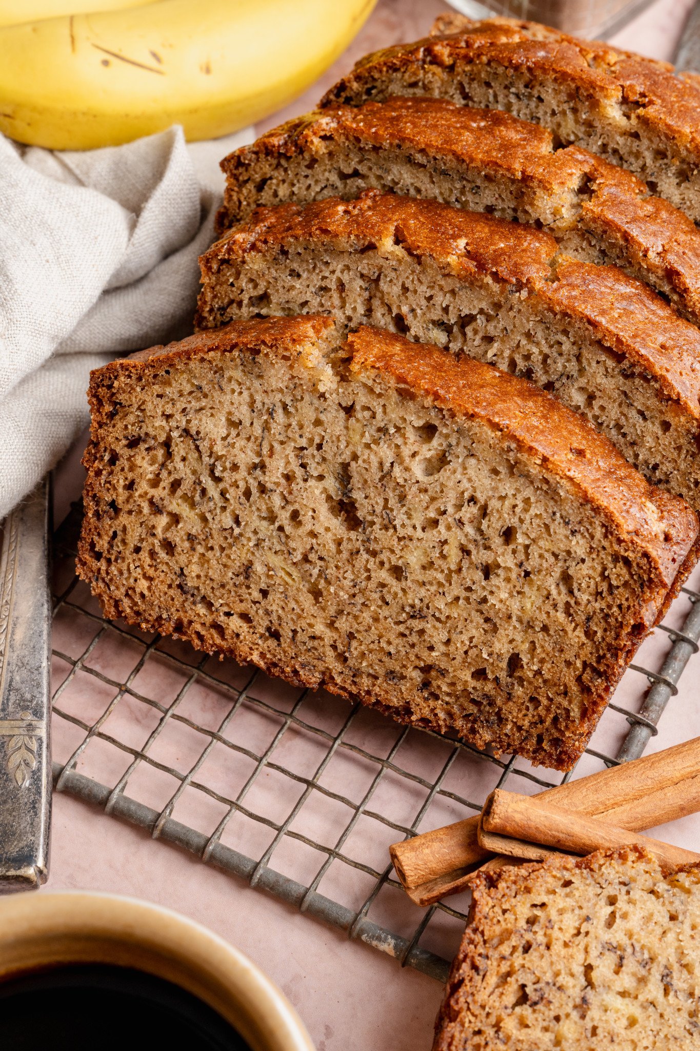 Slices of brown butter banana bread on wire rack.