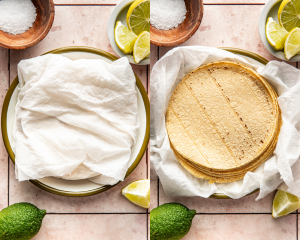 Side-by-side image of warming corn tortillas in a damp paper towel.