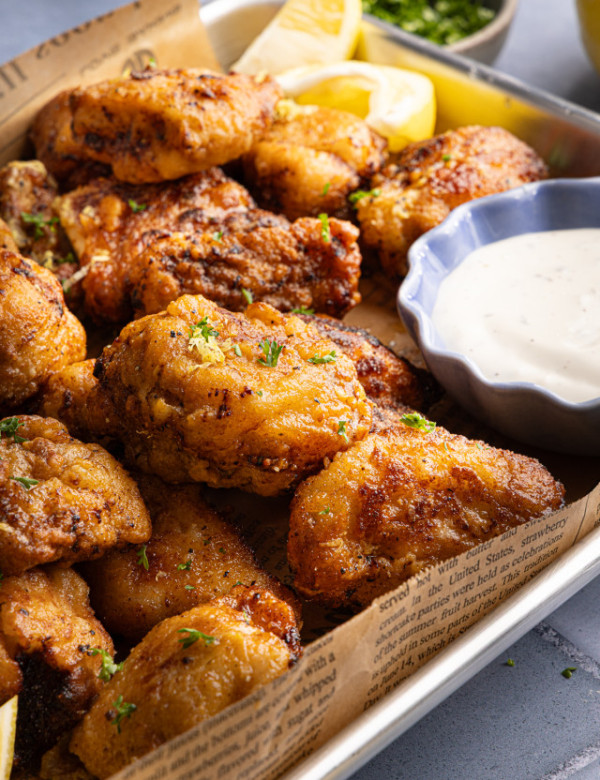 Cooked lemon pepper wings on parchment-lined baking tray.
