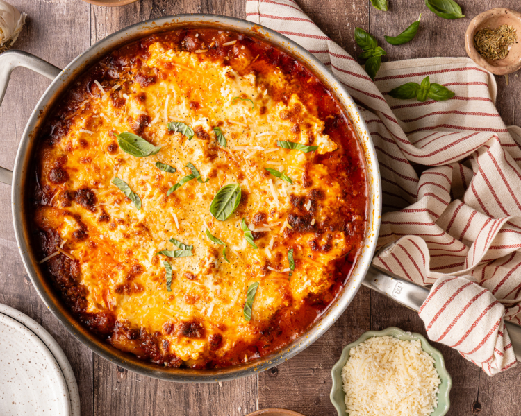 Gnocchi lasagna cooked in pan and garnished with fresh basil.