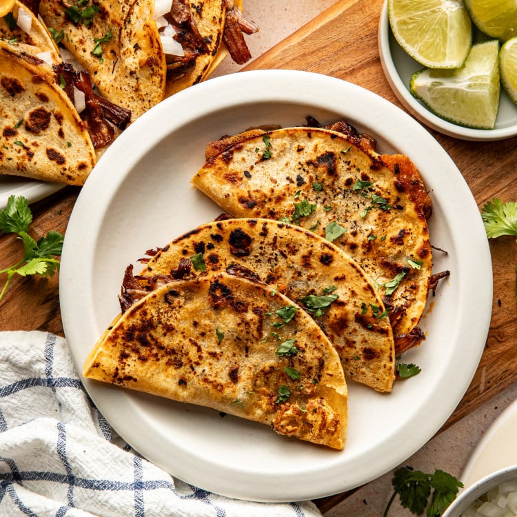 Three birria tacos on plate.