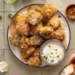 Plate of baked garlic parmesan boneless wings with a side of parmesan aioli on the side.