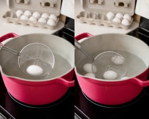 First image shows a white egg being lowered into boiling water with a stainless steel spider strainer; second image shows multiple white eggs gently placed into the hot water using the strainer.