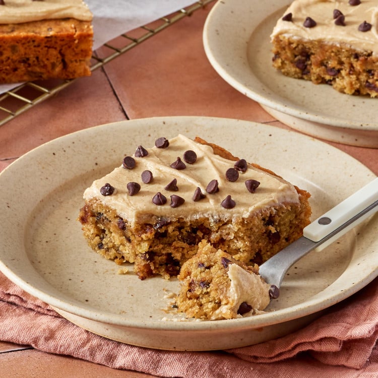 Fork cutting into banana chocolate chip bar to show inside of cake-like bar.