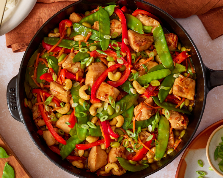 Cashew chicken stir fry cooked in skillet.