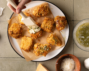 Pastry brush brushing cooked wings.