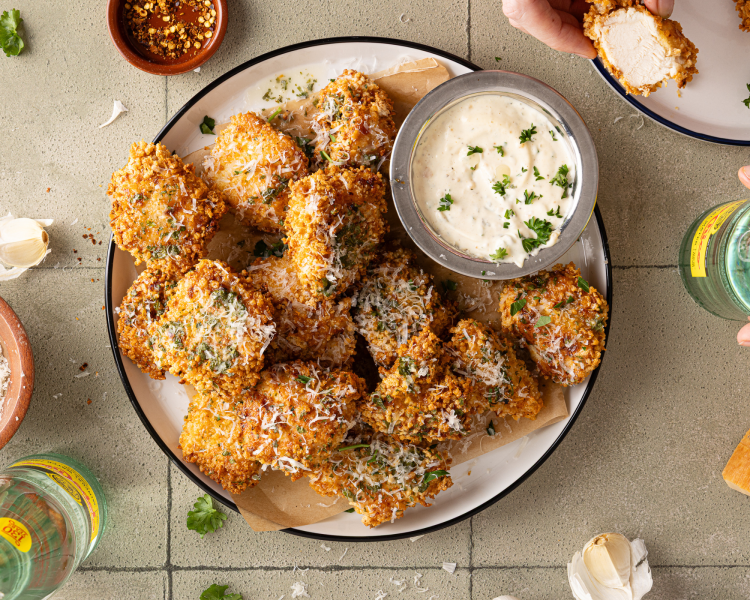 Air fried parmesan garlic chicken wings on plate with small dish of aioli on the side.