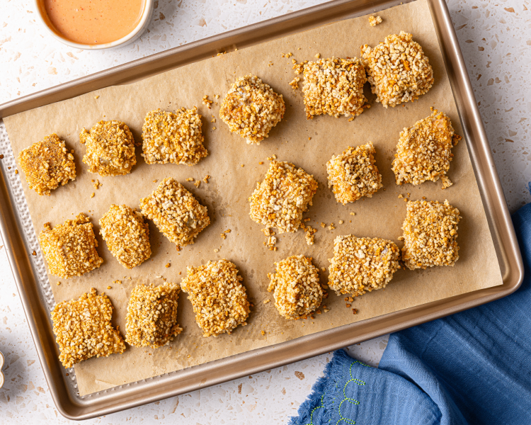 Baked salmon nuggets on a parchment-lined baking tray.