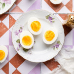 Three air fryer hard boiled eggs on a floral plate.