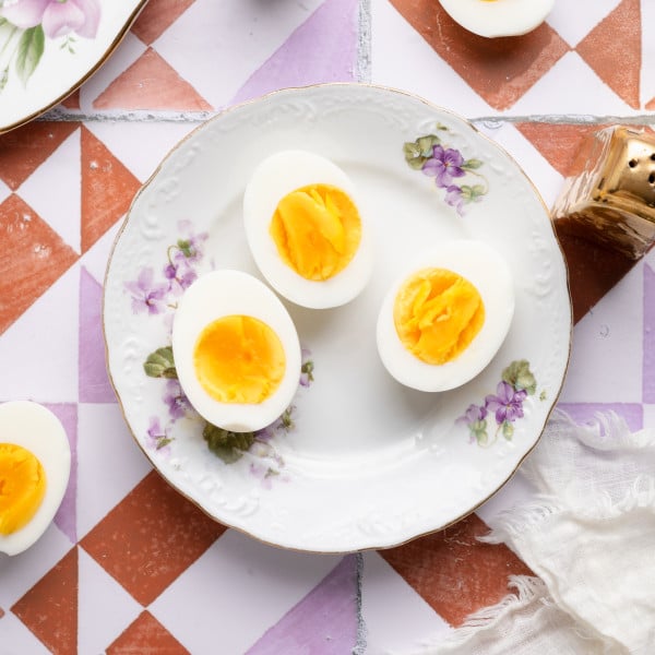 Three air fryer hard boiled eggs on a floral plate.