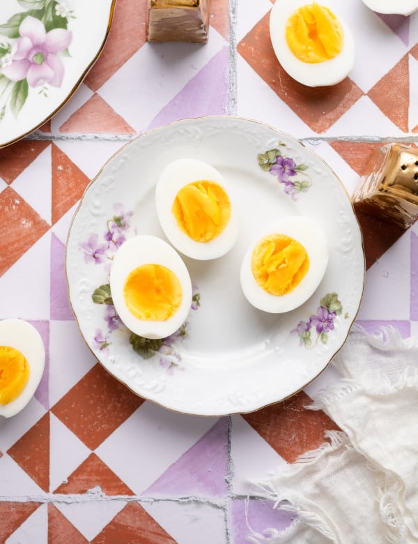 Three air fryer hard boiled eggs on a floral plate.